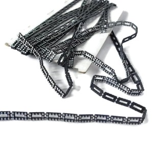 Taśma ozdobna plastikowa w kolorze czarno-szarym, można ją przyszywać lub przyklejać - rozmiar oczka 20 mm  x 10 mm