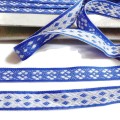 Taśma ozdobna produkcji czeskiej, - wzór wytłaczany haftowany, - kolor biały z niebieskim, dwustronna,     może być wykorzystana jako lampas - szerokość 1,60 cm