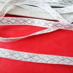 Taśma biała, haftowana  srebrną nitką, poliestrowa - szerokość ze srebrną nitką 9 mm do stosowania w krawiectwie, do zdobienia, lampas