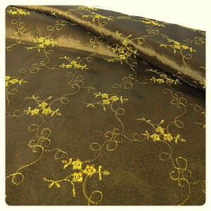 Tkanina tafta w kolorze złoto- oliwkowym-zielonym z haftem w kolorze żółto złotym, nie uciąga się, półmatowa - szerokość: 148 cm - skład: poliester z wiskozą