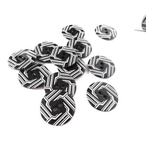 Guzik plastikowy w kolorze biało-czarnym, lakierowany o średnicy 28 mm, płaszczowy, do kurtek, swetrów