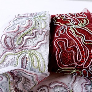 Taśma ozdobna haftowana na tiulu, z cekinami, do celów ozdobnych, do stosowania w krawiectwie,  - produkcja czeska.  - szerokość:  haftu 7 cm, tiulu 10 cm  -  kolory: biała, bordowa